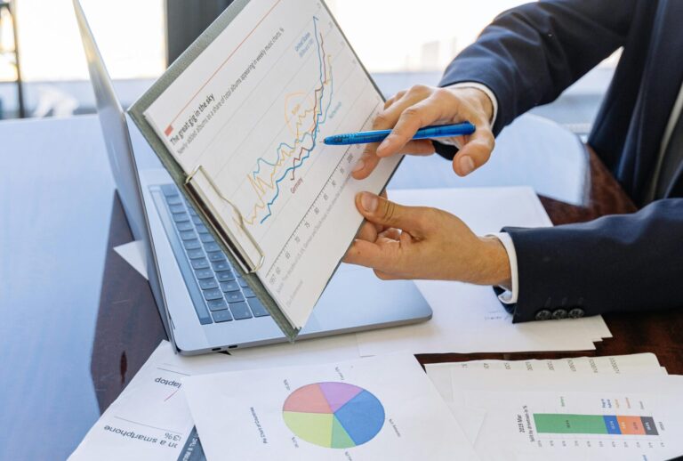 Business professionals discussing financial graphs and charts in an office setting.
